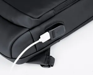 Detail of waterproof matte black sling bag featuring an external USB charging port