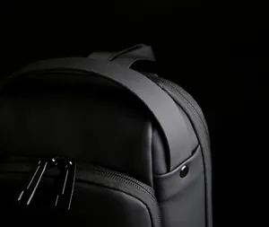 Detail view of water-resistant nylon chest bag featuring dual zippers and top handle