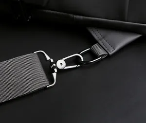Detail of high-density gray woven strap and matte metal hook on the black biker bag