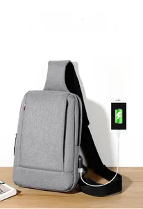 Detailed view of the side USB charging port on the gray oxford chest bag for men