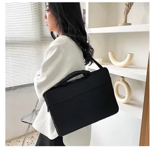Borsa porta PC nera minimalista con tracolla, indossata per il pendolarismo aziendale