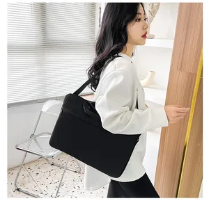 Borsa porta pc nera in tessuto impermeabile mostrata con un modello in ufficio
