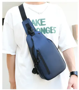 Gros plan d'un sac bandoulière imperméable bleu marine pour homme porté par un mannequin