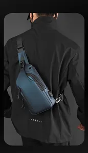 Vista posteriore di un modello con borsa da petto uomo blu scuro impermeabile e porta USB