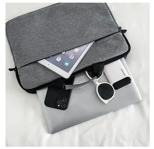 Vista dettagliata della borsa grigia con scomparti per laptop e accessori digitali