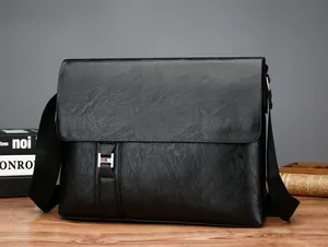 Détail d'un sac messager en cuir noir grainé avec une boucle métallique en H argentée élégante