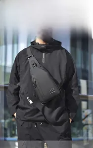 Detailed street style view of a black waterproof men's chest bag with matte finish