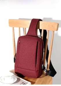 Macro view of the waterproof oxford fabric and USB charging port on the burgundy chest bag