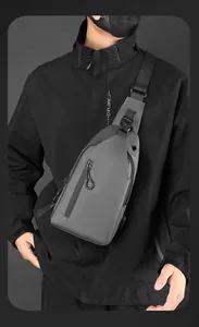 Dettaglio del tessuto opaco impermeabile e tasche con cerniera del borsello grigio uomo