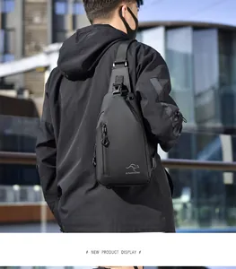 Close-up of waterproof black crossbody bag with functional zippers and headphone port detail
