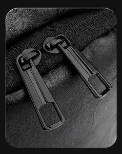 Detailaufnahme der glatten Doppelreißverschlüsse und Lederstruktur der schwarzen Tasche