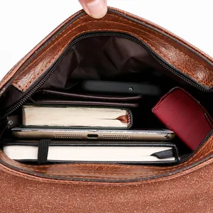 Sacoche homme minimaliste en cuir marron montrant un grand compartiment pour tablette
