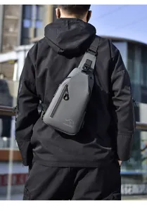 Outdoor shot of a man wearing a grey waterproof crossbody bag with a logo detail