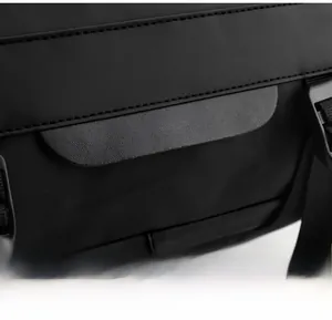 Gros plan détaillé du tissu noir du sac à dos, garniture en cuir et boucle plastique
