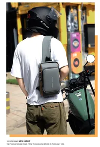 Detail view of anti-theft combination lock and USB charging port on men's gray chest bag