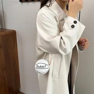 Chic white basketball shaped crossbody bag with gold chain and black script lettering