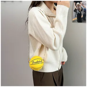 Fashionable yellow basketball-shaped crossbody bag with gold chain strap shown on model