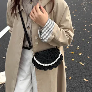 Chic black shell-shaped crossbody bag with decorative pearl chain and quilted texture