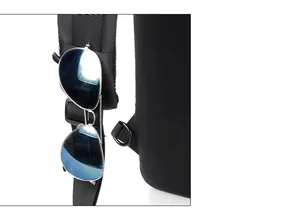 Detail of shoulder strap webbing with attachment system holding blue sunglasses