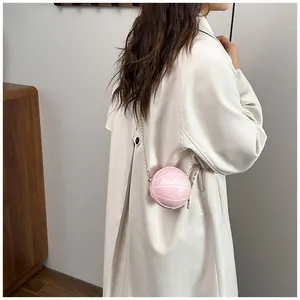 Pink basketball shaped mini crossbody bag with gold chain strap and textured finish