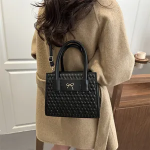 Large capacity black quilted leather tote bag with gold bow detail and shoulder strap