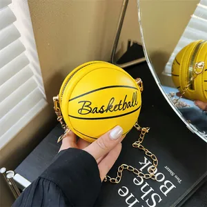 Detail of yellow basketball crossbody bag with gold chain strap and textured finish