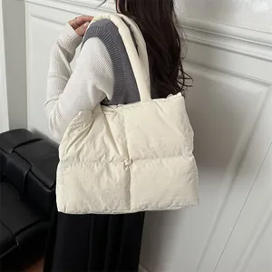 Quilted puffer tote bag in cream white nylon fabric shown from a side-back view