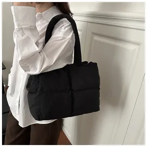 Detail of the black quilted puffer tote bag showing the soft padded texture and stitching