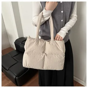 Quilted beige puffer tote bag styled with a casual look in a modern indoor setting