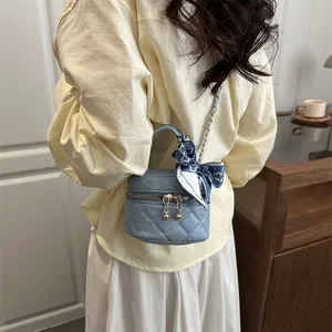 Light blue quilted mini crossbody bag with gold chain and silk scarf tied to the strap