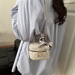 White quilted mini crossbody bag with gold chain strap and silk scarf handle detail