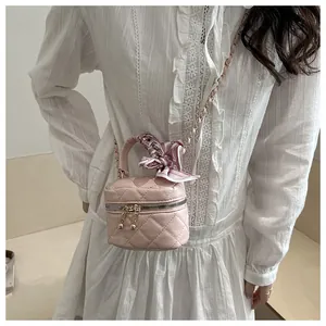 Close-up of pink quilted mini bag with floral scarf handle and gold chain strap