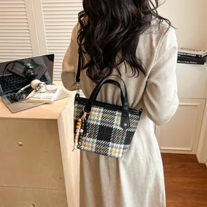Borsa tote a quadri con manici in pelle e perline in legno in un ambiente di vita reale