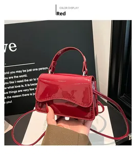 Détail du mini sac à main en cuir verni rouge montrant la texture brillante