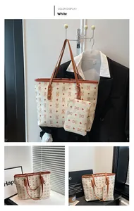 Detail of white tote bag with bear pattern print, brown leather trim and small pouch