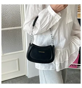 Detailansicht einer schwarzen Hobo-Tasche mit Goldlogo und schickem Silberketten-Griff