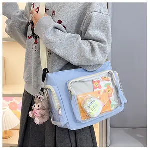 Detail of light blue itabag showing transparent PVC window and plush bear accessory