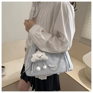Détail du sac bandoulière bleu clair avec chaîne en perles et breloque nuage peluche