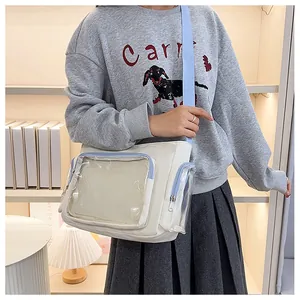 Close-up of white canvas ita bag with blue trim and transparent front window pocket