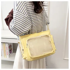 Detailed view of yellow canvas ita bag with transparent window for display and long strap