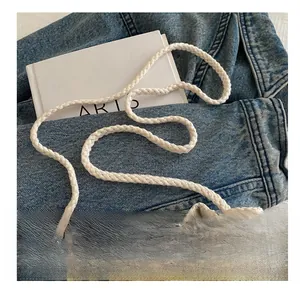 Detail of cream woven bucket bag with herringbone texture and thick cotton rope strap