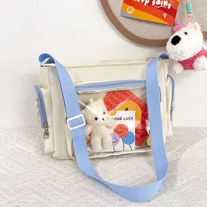 Detail of cute beige ita bag with clear window showing white plush bear and pins