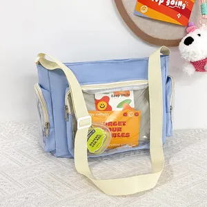 Detail of light blue ita bag showing transparent front pocket and multi-zippered design