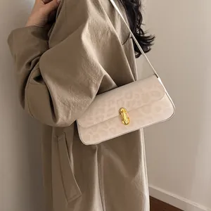 Chic cream leopard print shoulder bag for women styled with a khaki trench coat