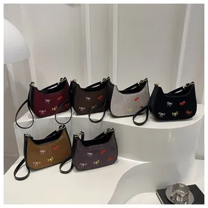 Détails de six sacs en daim colorés avec broderies de papillons délicates et élégantes