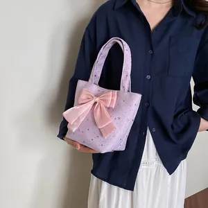 Bolso tote de lona morada con estampados de estrellas plateadas y lazo de satén rosa