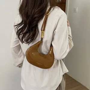 Chic brown crescent leather hobo bag with adjustable strap and metallic hardware