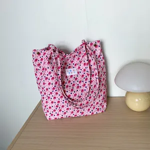 Détail du sac cabas rose texturé avec motifs floraux et détails de rivets métalliques