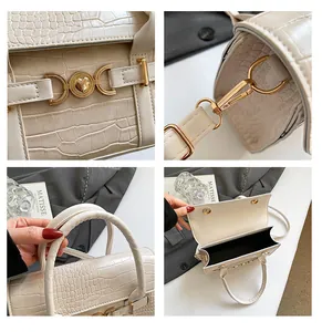 Detail of cream faux crocodile handbag with gold heart buckle and refined stitching
