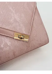 Detailed macro view of the pearlescent textured leather and golden turn-lock on the handbag